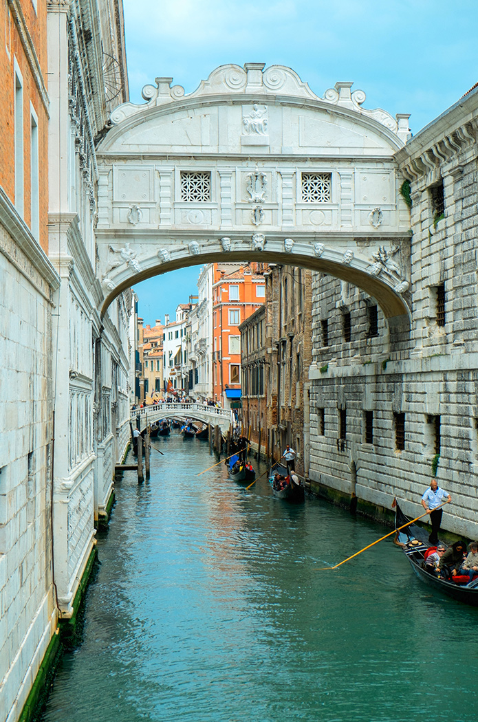 Tourists and gondaliers passing under the Bridge of Sighs Venice